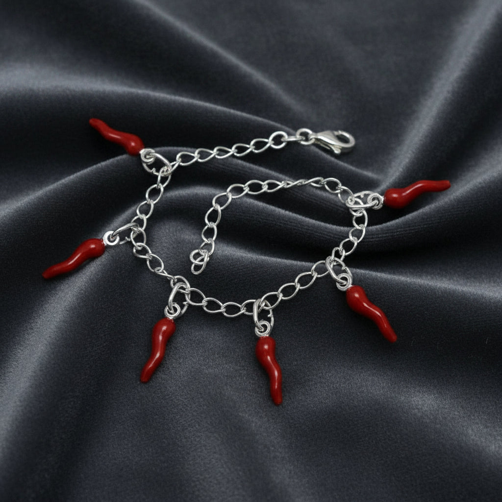 Bracciale in argento 925 con sei corni rossi scaramantici su velluto grigio antracite con effetto onda radiale.