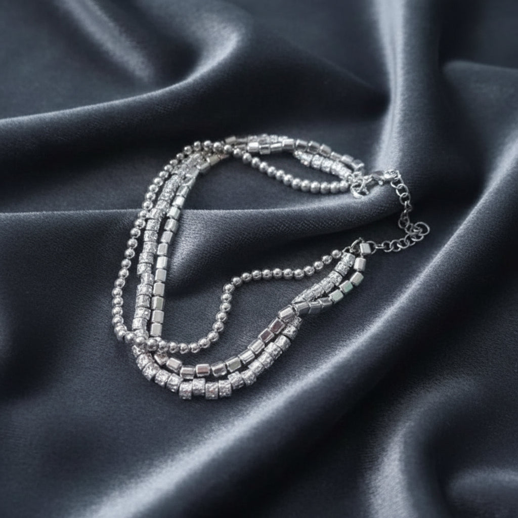 Bracciale a tre fili in argento 925 con pepite stile Dodo su sfondo velluto grigio antracite a onde.