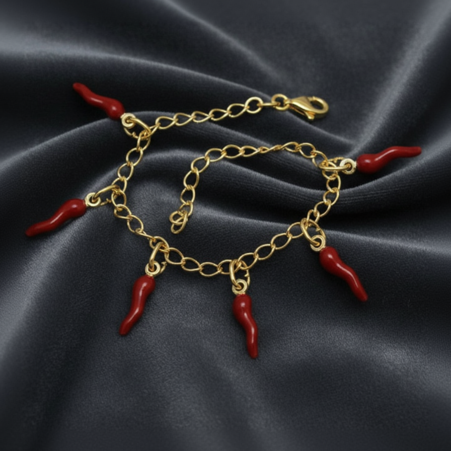 Bracciale giallo in argento 925 con sei corni rossi scaramantici su velluto grigio antracite con effetto onda radiale.