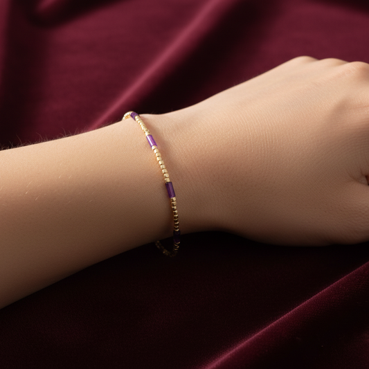 Bracciale in oro giallo 18kt con elementi colorati, produzione Art MiD Gioielli presentato su velluto bordeaux con effetto onda