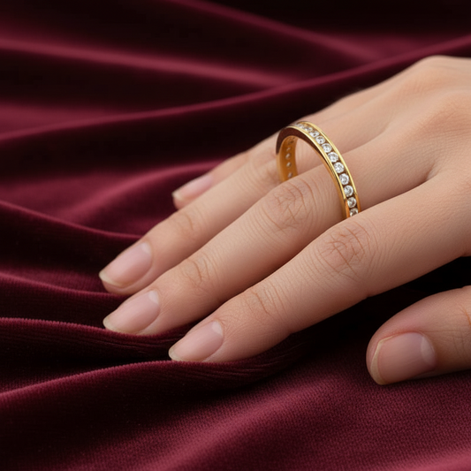 Dettaglio zirconi incastonati su veretta in oro giallo 750 su velluto bordeaux effetto onda.