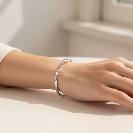 Primo piano della frase incisa al laser su bracciale rigido ArtMID in argento.