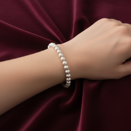 Dettaglio sfere 5mm del bracciale in oro 750 peso 5,00g su astuccio effetto onda.