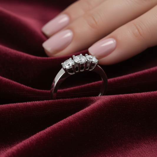 ADettaglio montatura a tre pietre in oro bianco 750 su velluto bordeaux a onde