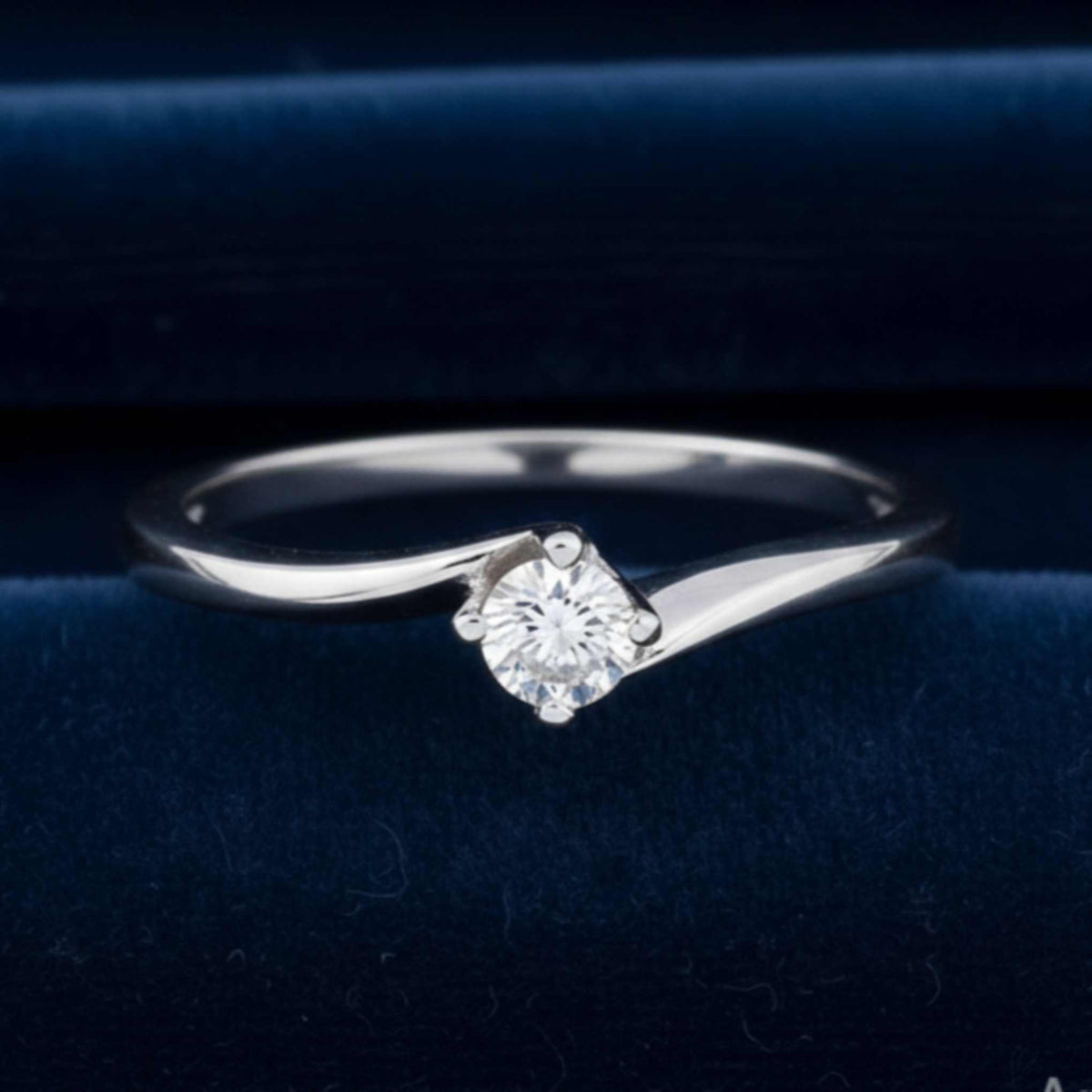 Anello solitario modello Valentino in oro bianco 18kt con diamante naturale da 0.20 ct su velluto burgundy.