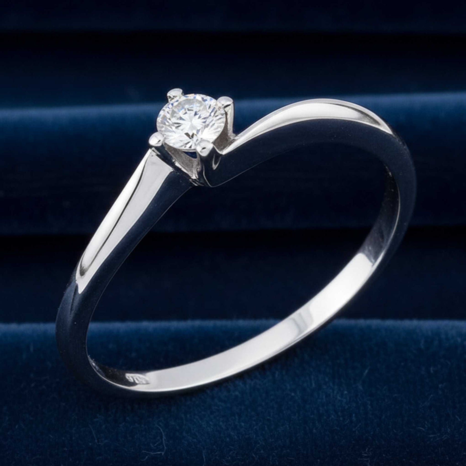 Inquadratura verticale dell'anello Valentino che mostra l'intero gambo in oro bianco e il castone con diamante.