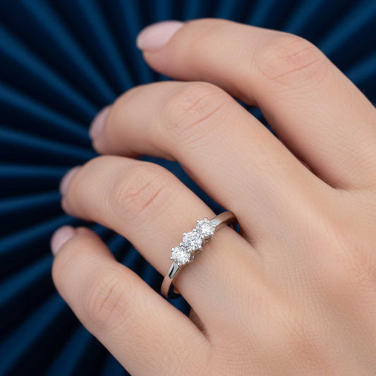 Primo piano dell'anello Trilogy da 0,30 ct indossato, dettaglio della luce e della manifattura artigianale.