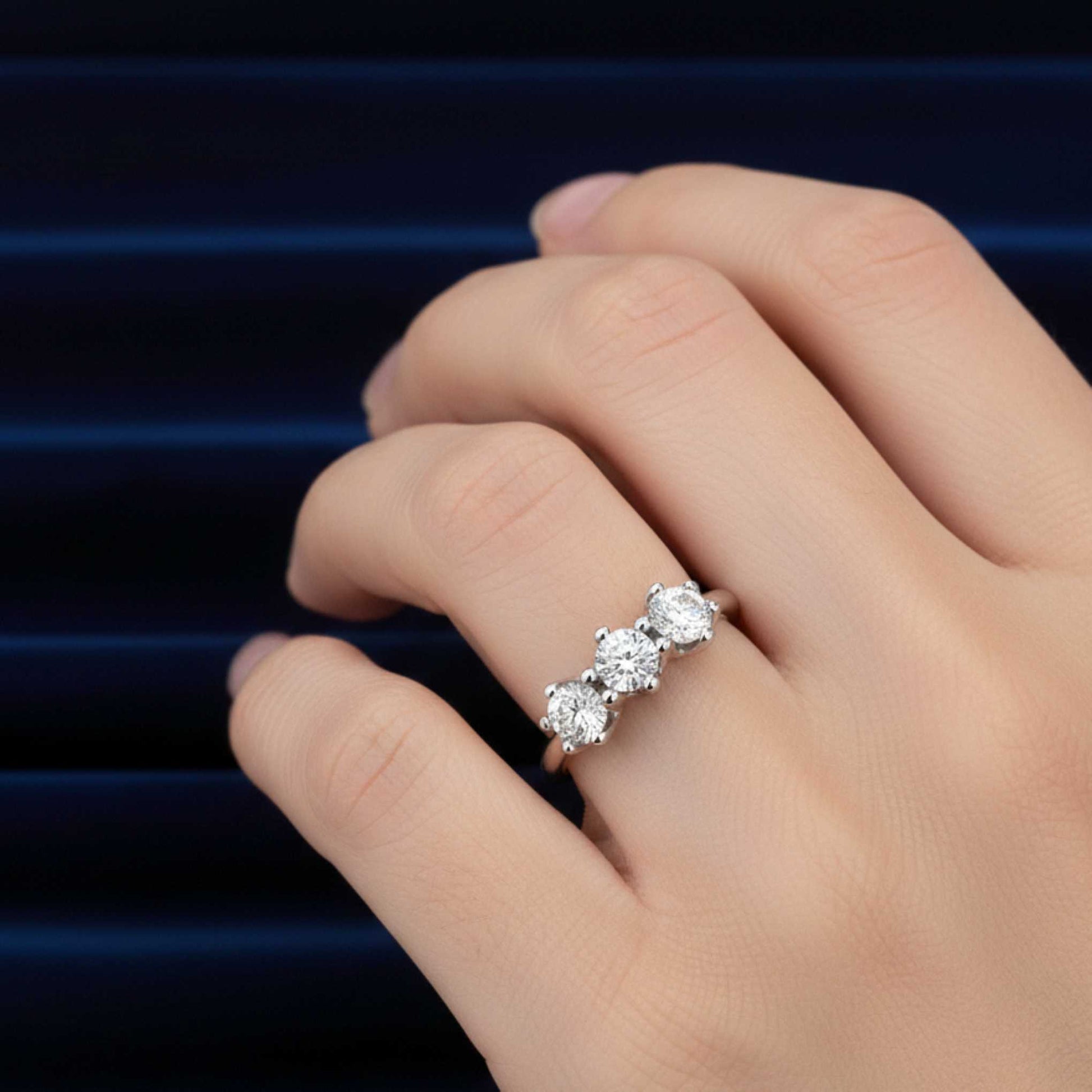Primo piano di una mano che indossa l'anello Trilogy da 3,30 carati, massima espressione del lusso ArtMID.