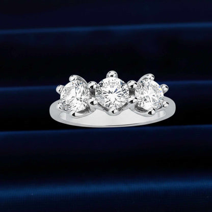 Anello Trilogy d'alta gioielleria con tre grandi diamanti naturali da 3,30 ct totali su velluto burgundy.