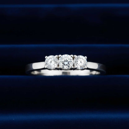 Anello Trilogy in oro bianco 18kt con tre diamanti naturali da 0,90 ct totali su velluto burgundy.
