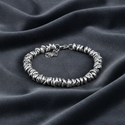 Bracciale in argento 925 rodiato con anelli mobili stile Dodo su velluto grigio antracite con effetto onda.