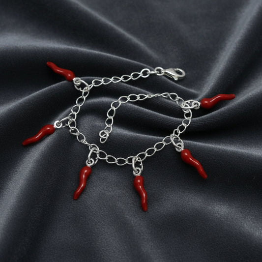 Bracciale in argento 925 con sei corni rossi scaramantici su velluto grigio antracite con effetto onda radiale.