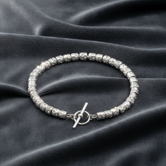 Bracciale in argento 925 rodiato con pepite mobili stile Dodo su velluto grigio antracite con effetto onda.