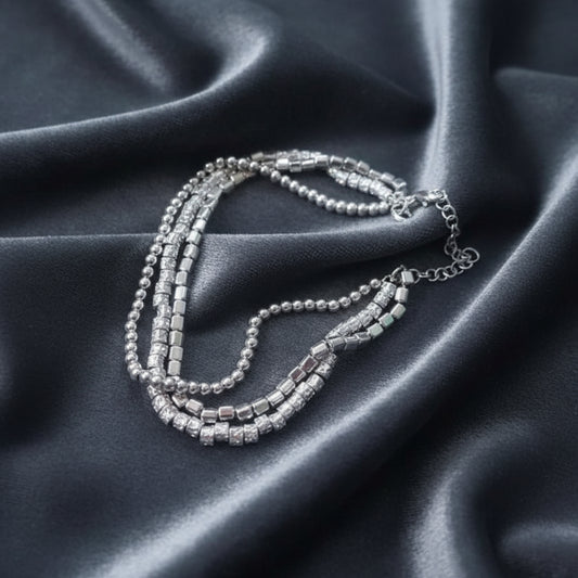 Bracciale a tre fili in argento 925 con pepite stile Dodo su sfondo velluto grigio antracite a onde.