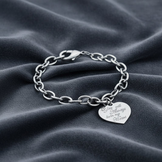 Bracciale a catena in argento 925 con pendente a cuore su velluto grigio antracite con effetto onda.