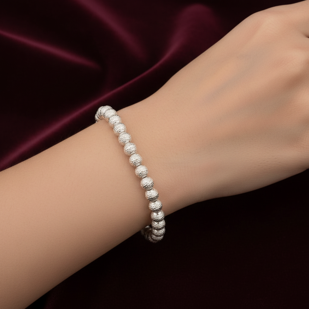 Bracciale in oro indossato 18kt con sfere martellate su esclusivo sfondo in velluto verde bosco con effetto onda.