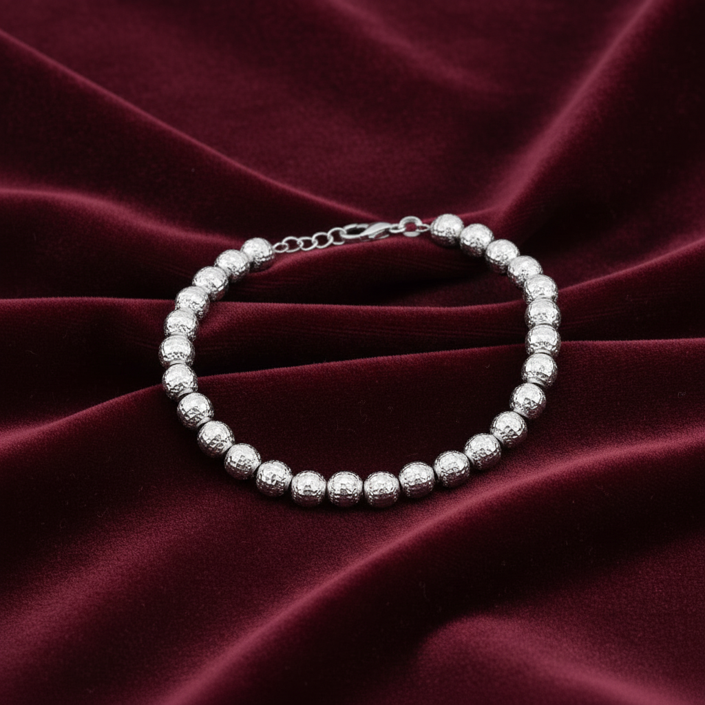 Bracciale Milleluci in oro bianco 18kt con sfere diamantate da 6mm, peso 6.10g, presentato su velluto bordeaux a onde.