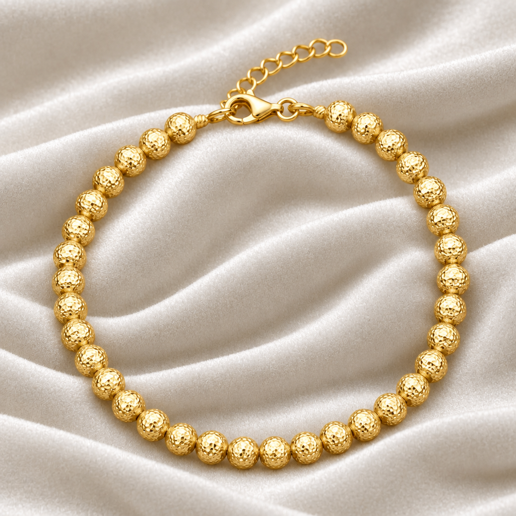 Bracciale in oro giallo 18kt con sfere martellate su esclusivo sfondo in velluto verde bosco con effetto onda.