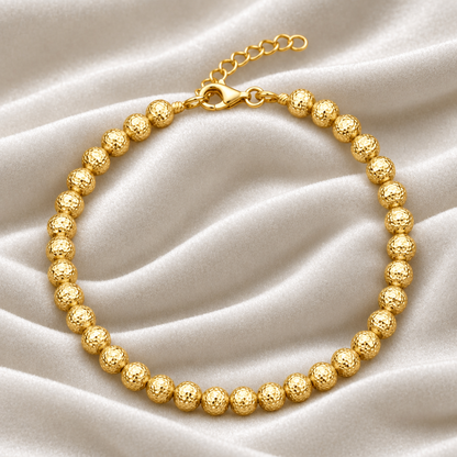Bracciale in oro giallo 18kt con sfere martellate su esclusivo sfondo in velluto verde bosco con effetto onda.