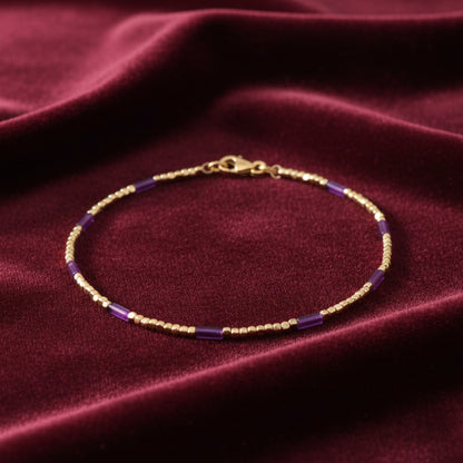 Bracciale in oro giallo 18kt con elementi colorati, produzione Art MiD Gioielli presentato su velluto bordeaux con effetto onda.