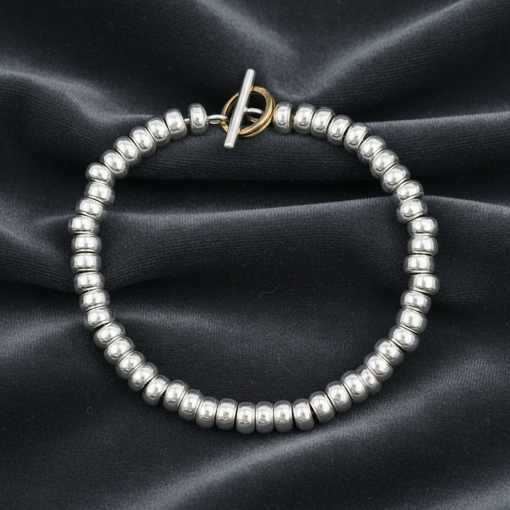 Bracciale Rondelle ArtMID in argento 925 su sfondo velluto grigio antracite con effetto onda.
