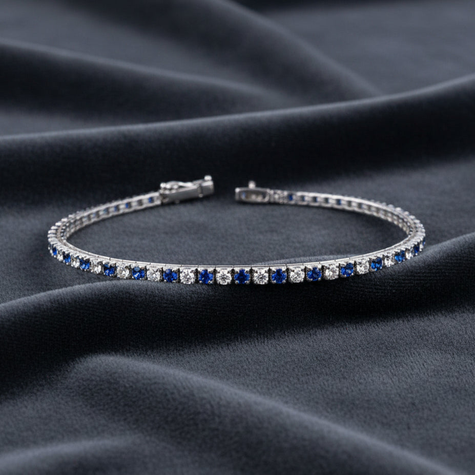 Bracciale tennis ArtMID in argento 925 con pietre blu e bianche su sfondo velluto blu radiale.