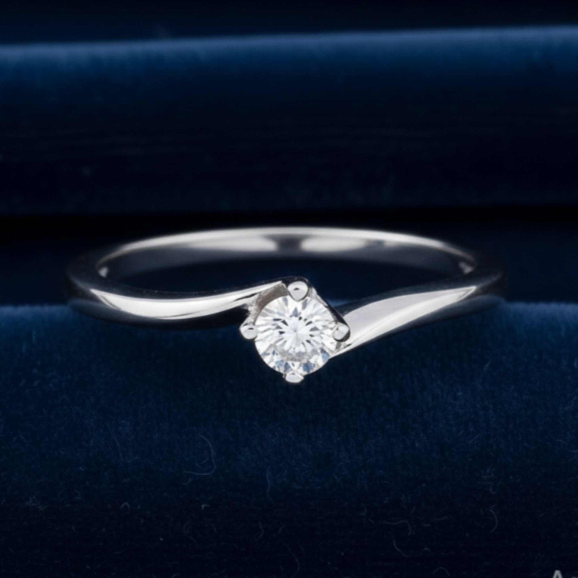Anello solitario modello Valentino in oro bianco 18kt con diamante naturale da 0.20 ct su velluto burgundy.